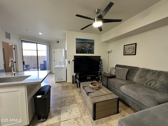 living area featuring stone tile flooring, visible vents, recessed lighting, and ceiling fan