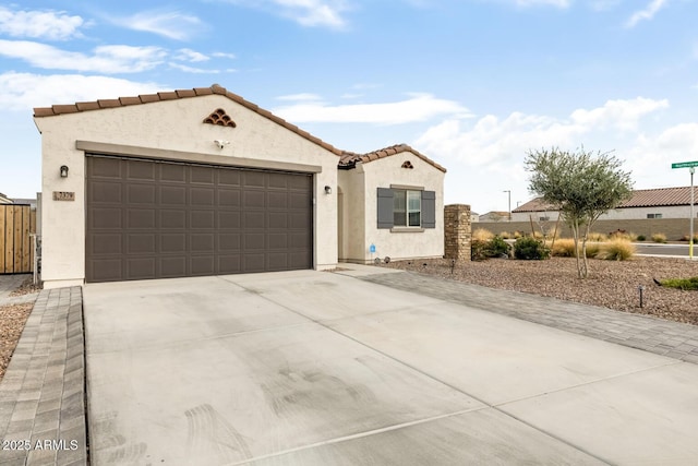 mediterranean / spanish-style house with stucco siding, driveway, fence, a garage, and a tiled roof