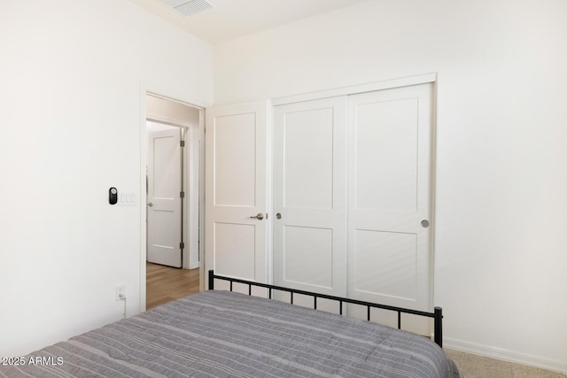 bedroom featuring carpet flooring, visible vents, and a closet