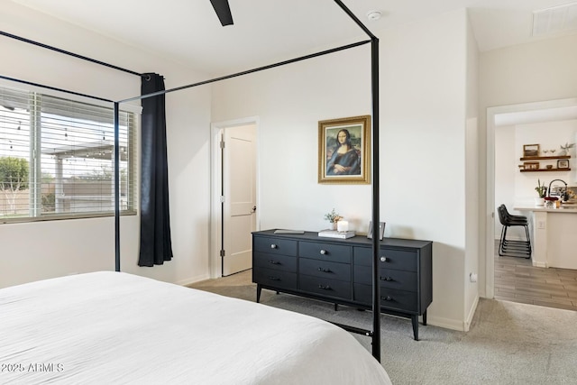 bedroom with visible vents, baseboards, light colored carpet, and ceiling fan