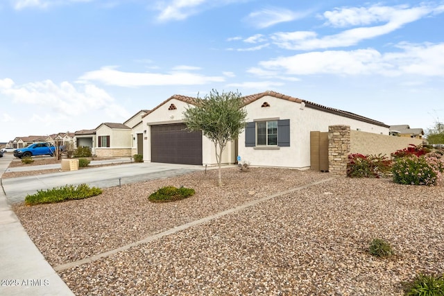 view of front facade with a tile roof, concrete driveway, a garage, and stucco siding