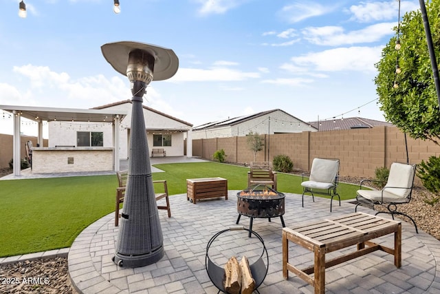 view of patio featuring a fenced backyard, outdoor dry bar, and an outdoor fire pit