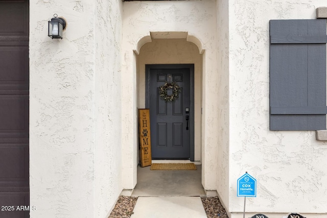 view of exterior entry with stucco siding