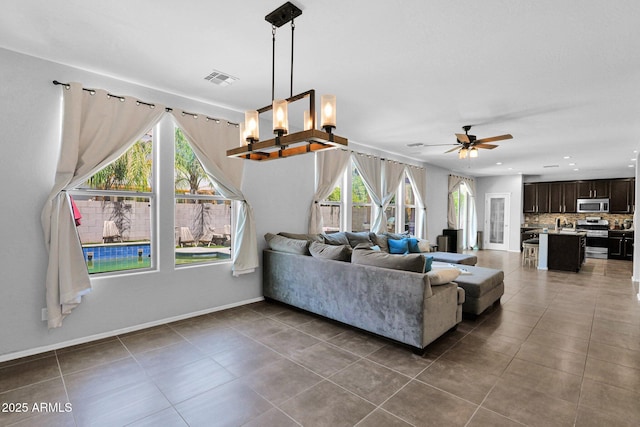 3436 E Gary Way, Gilbert, AZ 85234 - living area featuring tile patterned flooring, plenty of natural light, and ceiling fan with notable chandelier