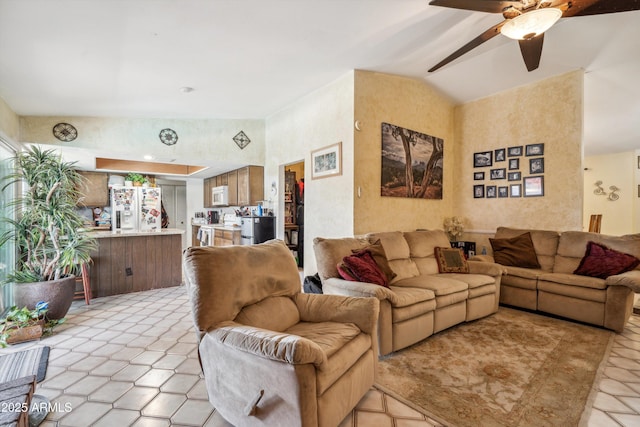 living room featuring lofted ceiling, ceiling fan, and light tile patterned flooring