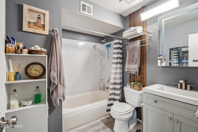 bathroom with a textured wall, toilet, shower / bathtub combination with curtain, and vanity