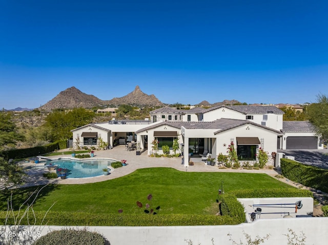 back of property featuring stucco siding, a lawn, a patio, a tile roof, and a mountain view