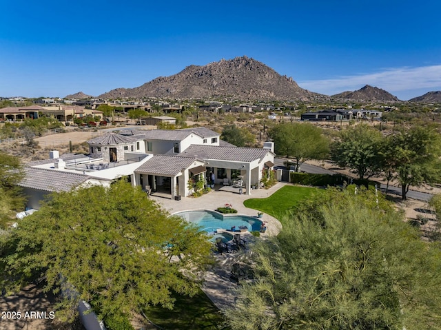 rear view of house with a tiled roof, a mountain view, stucco siding, and a patio area