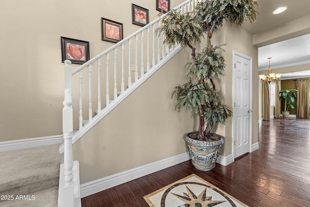 staircase with hardwood / wood-style flooring and a notable chandelier