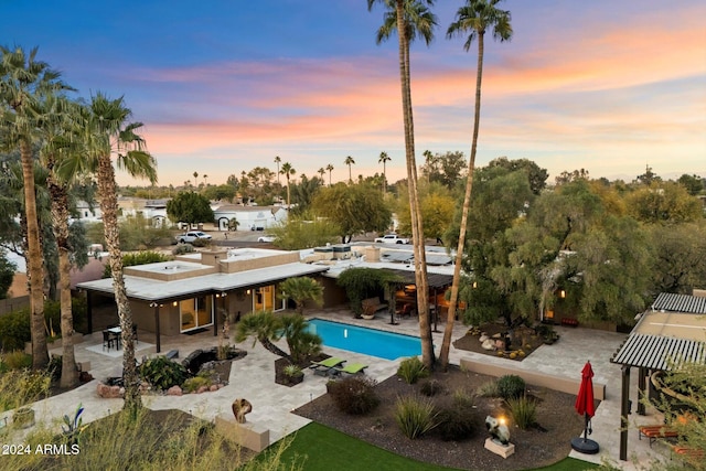 pool at dusk with a patio area