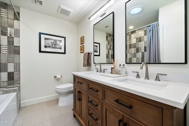 bathroom with tile patterned floors, vanity, a tub to relax in, and toilet