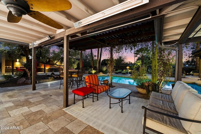 patio terrace at dusk with outdoor lounge area and ceiling fan