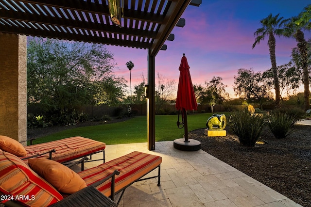 patio terrace at dusk with a pergola and a lawn