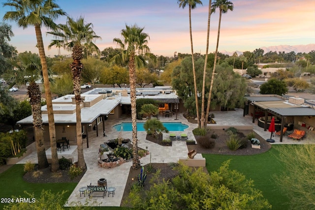 pool at dusk featuring a patio area