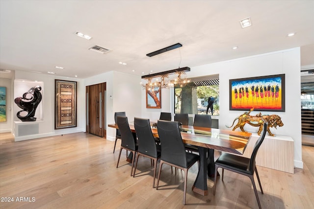 dining area with a notable chandelier and light wood-type flooring