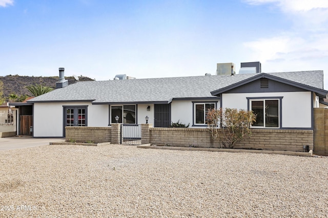 single story home with a shingled roof, fence, and brick siding