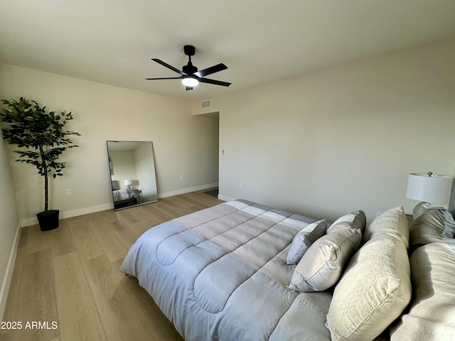 bedroom with light hardwood / wood-style floors and ceiling fan