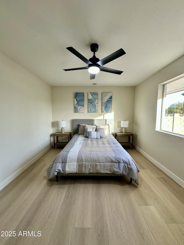 bedroom with light hardwood / wood-style floors and ceiling fan