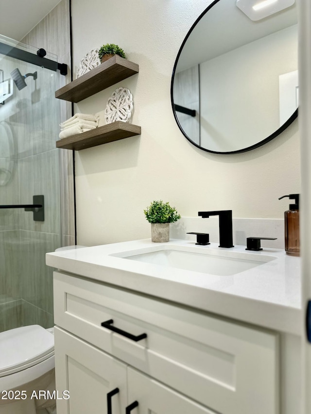 bathroom with toilet, a shower with shower door, and vanity