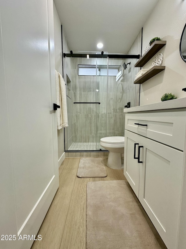 bathroom with toilet, walk in shower, and vanity