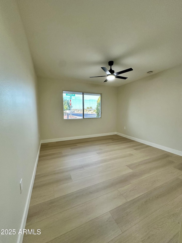 empty room with ceiling fan and light hardwood / wood-style floors