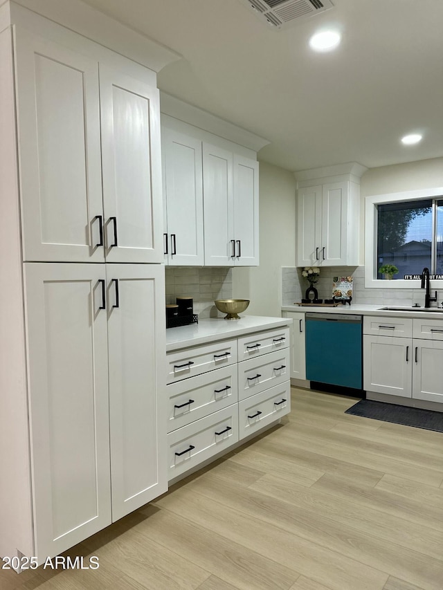 kitchen with decorative backsplash, sink, white cabinetry, and dishwasher