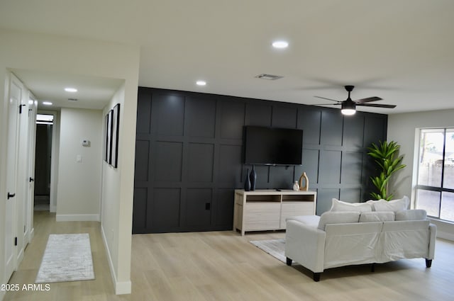 living room featuring ceiling fan, light hardwood / wood-style floors, and a wealth of natural light