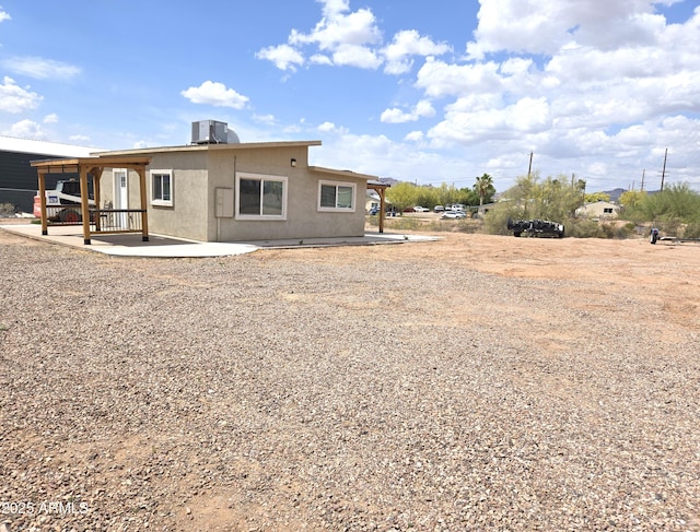 144 N Cactus Rd, Apache Junction, AZ 85119 - rear view of house featuring a patio, central AC unit, and stucco siding