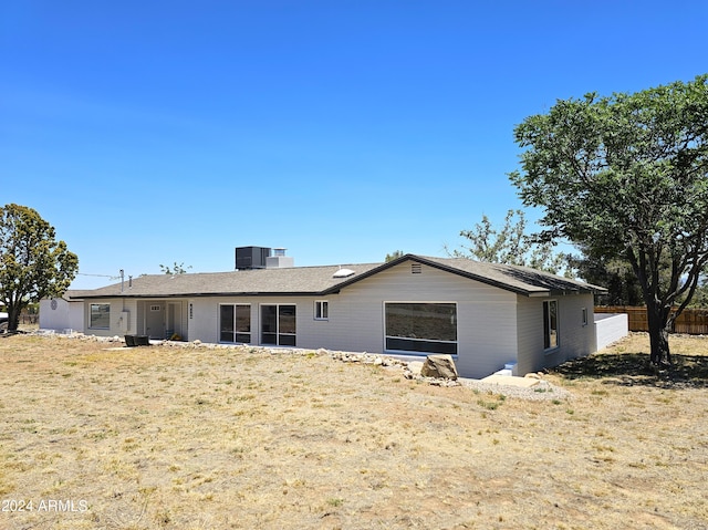 view of front of house featuring cooling unit and a front yard