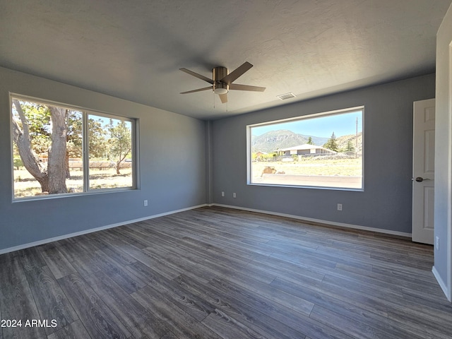 unfurnished bedroom with visible vents, baseboards, ceiling fan, and dark wood-style flooring