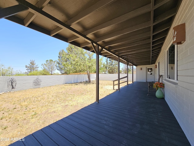 wooden terrace with a fenced backyard