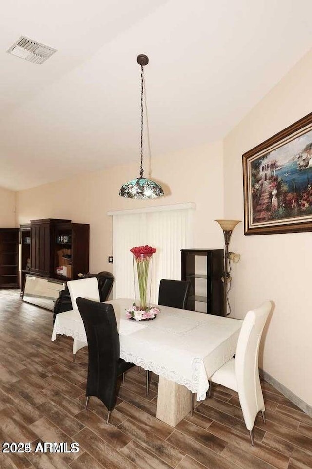 dining room featuring baseboards, visible vents, and wood finished floors