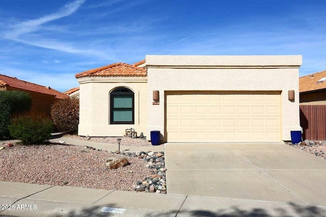 view of front of home with a garage, concrete driveway, a tile roof, and stucco siding