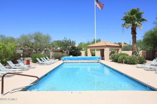 pool with fence, a patio, and a gazebo