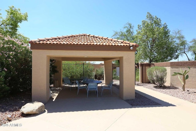 view of patio / terrace with outdoor dining space, fence, and a gazebo