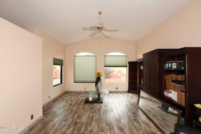 workout room featuring lofted ceiling, baseboards, and wood finished floors