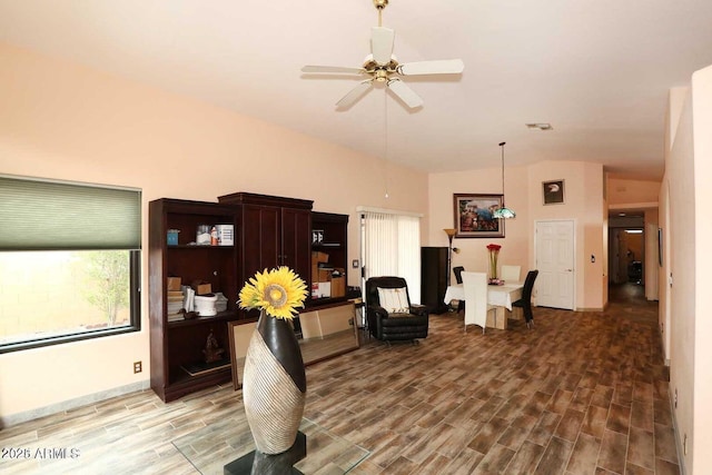 interior space featuring a ceiling fan, wood tiled floor, visible vents, and vaulted ceiling