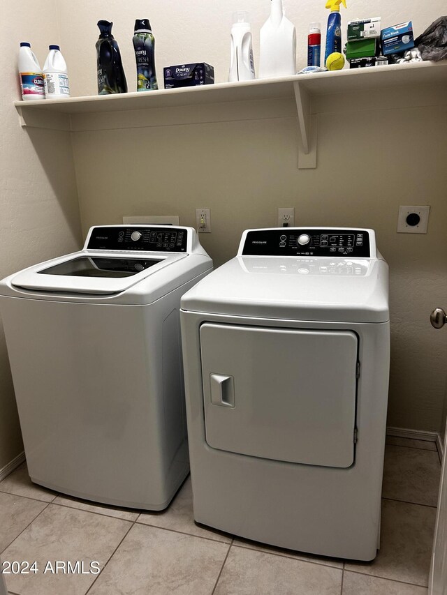 clothes washing area with light tile patterned floors and washing machine and clothes dryer