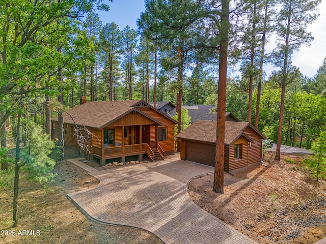 2721 W Snowberry Loop, Show Low, AZ 85901 - chalet / cabin with covered porch, a shingled roof, decorative driveway, an outdoor structure, and log exterior