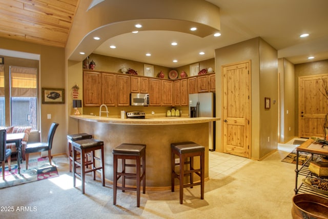2721 W Snowberry Loop, Show Low, AZ 85901 - kitchen featuring stainless steel appliances, a peninsula, light carpet, recessed lighting, and a kitchen breakfast bar