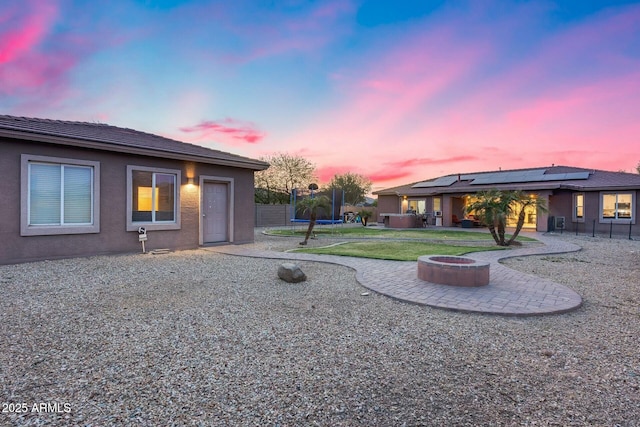 yard at dusk featuring a fire pit, a patio area, and fence