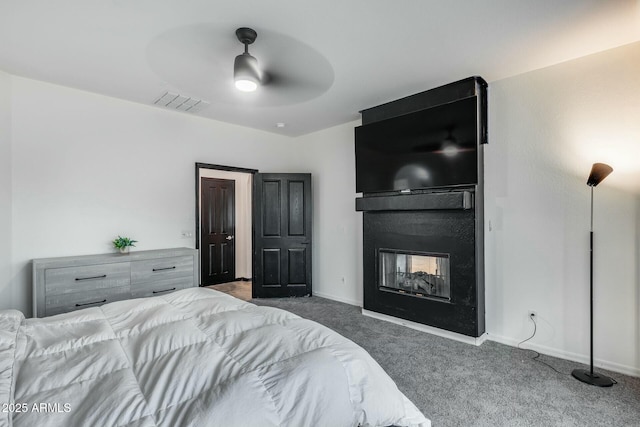 carpeted bedroom featuring visible vents, a ceiling fan, a multi sided fireplace, and baseboards