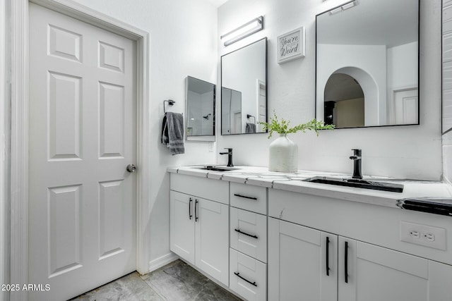 bathroom with double vanity, a sink, and marble finish floor