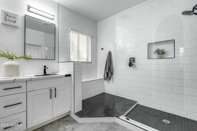 full bath with vanity, walk in shower, and marble finish floor