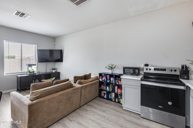 living area featuring light wood-style flooring and visible vents
