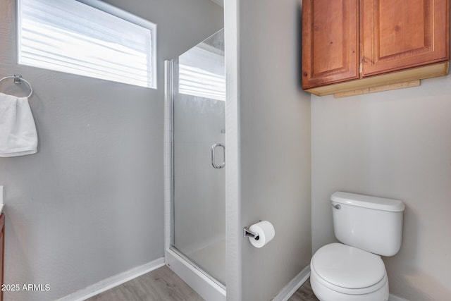 full bath featuring toilet, baseboards, and a stall shower