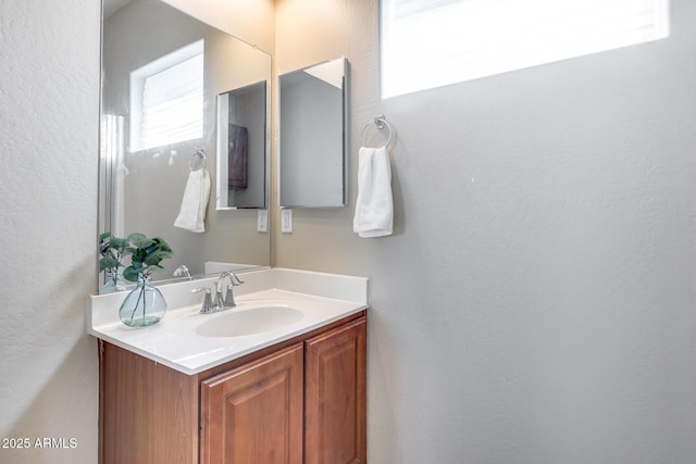 bathroom featuring vanity and a textured wall