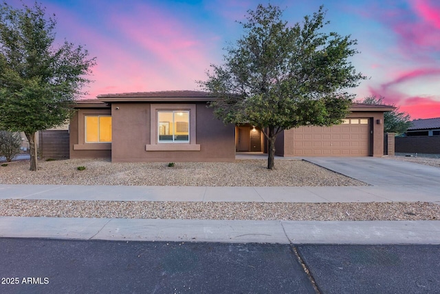 view of front facade featuring a garage, stucco siding, concrete driveway, and a tile roof