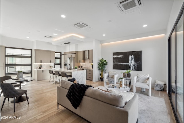 living room with light hardwood / wood-style flooring and sink