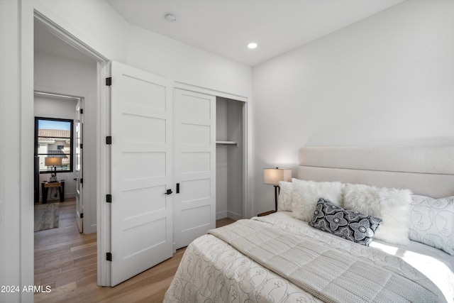 bedroom with light wood-type flooring and a closet